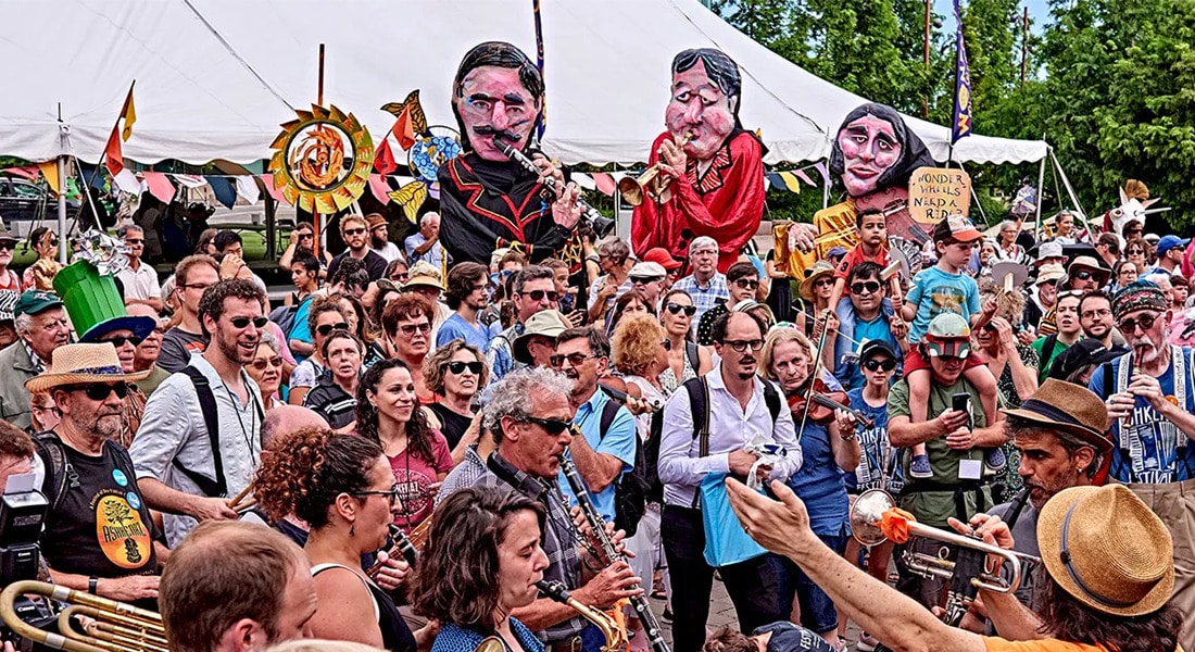 A large group of people celebrating, some are playing instruments.